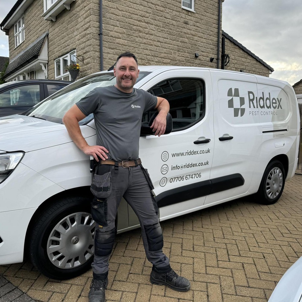 Riddex branded van with pest controller standing in front of it.